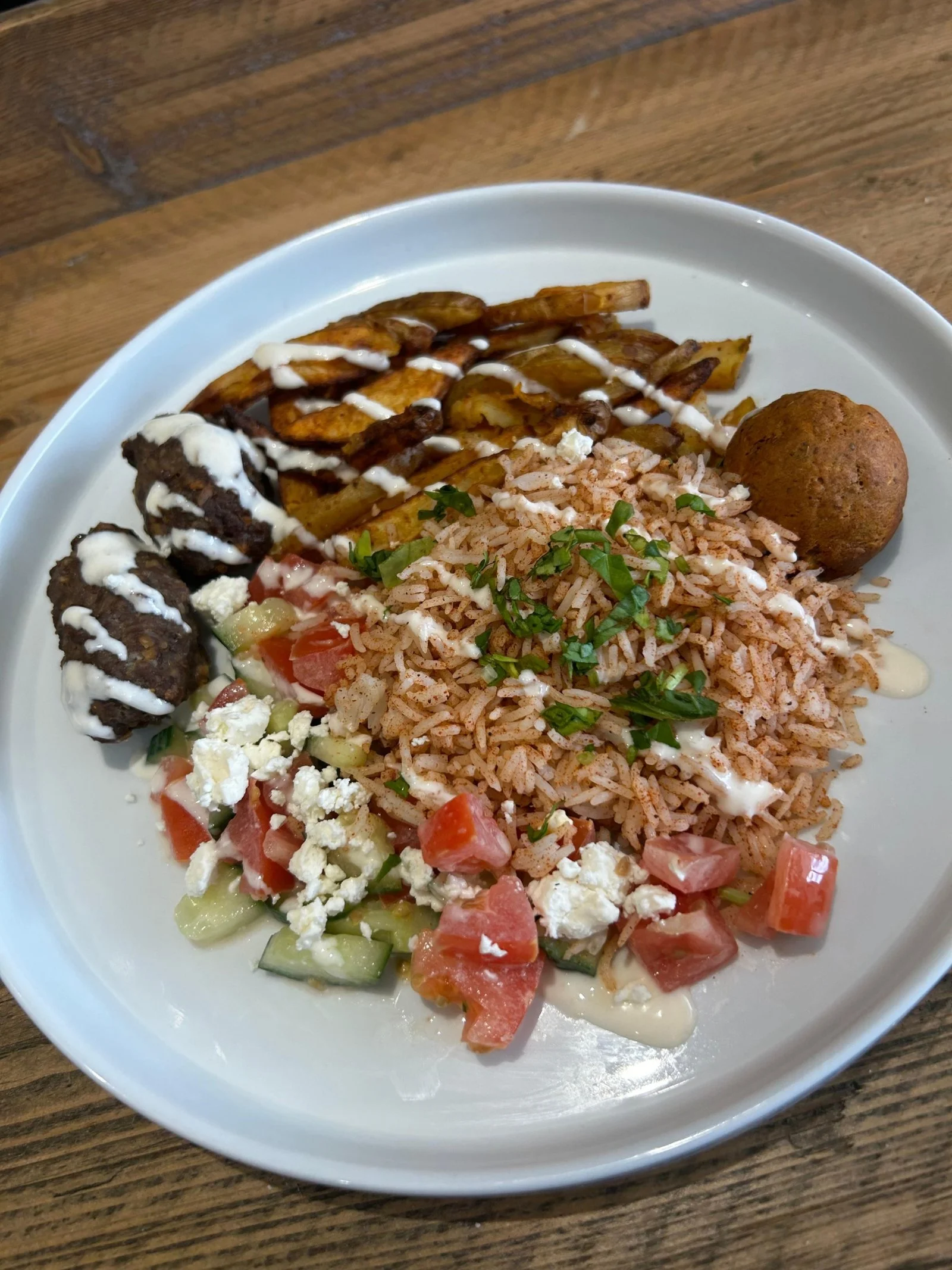 Greek Mezze Box, featuring a choice of protein, incl Chicken, Beef or an all plant version with Aubergine, over oven-baked wedges, herbed rice, falafel and salad.