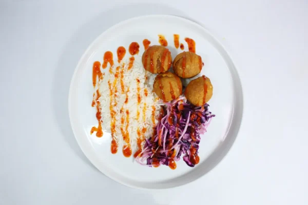 Healthy Sweet Potato Falafel paired with fluffy white rice, rainbow slaw, and drizzled with sweet chilli sauce, offering a vibrant and nutritious meal.