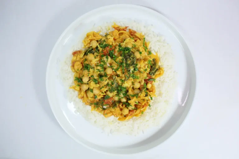 A vibrant dish of Chickpea and Spinach Curry served over a bed of fluffy basmati rice, featuring tender chickpeas, fresh spinach, and a rich, spiced curry sauce.