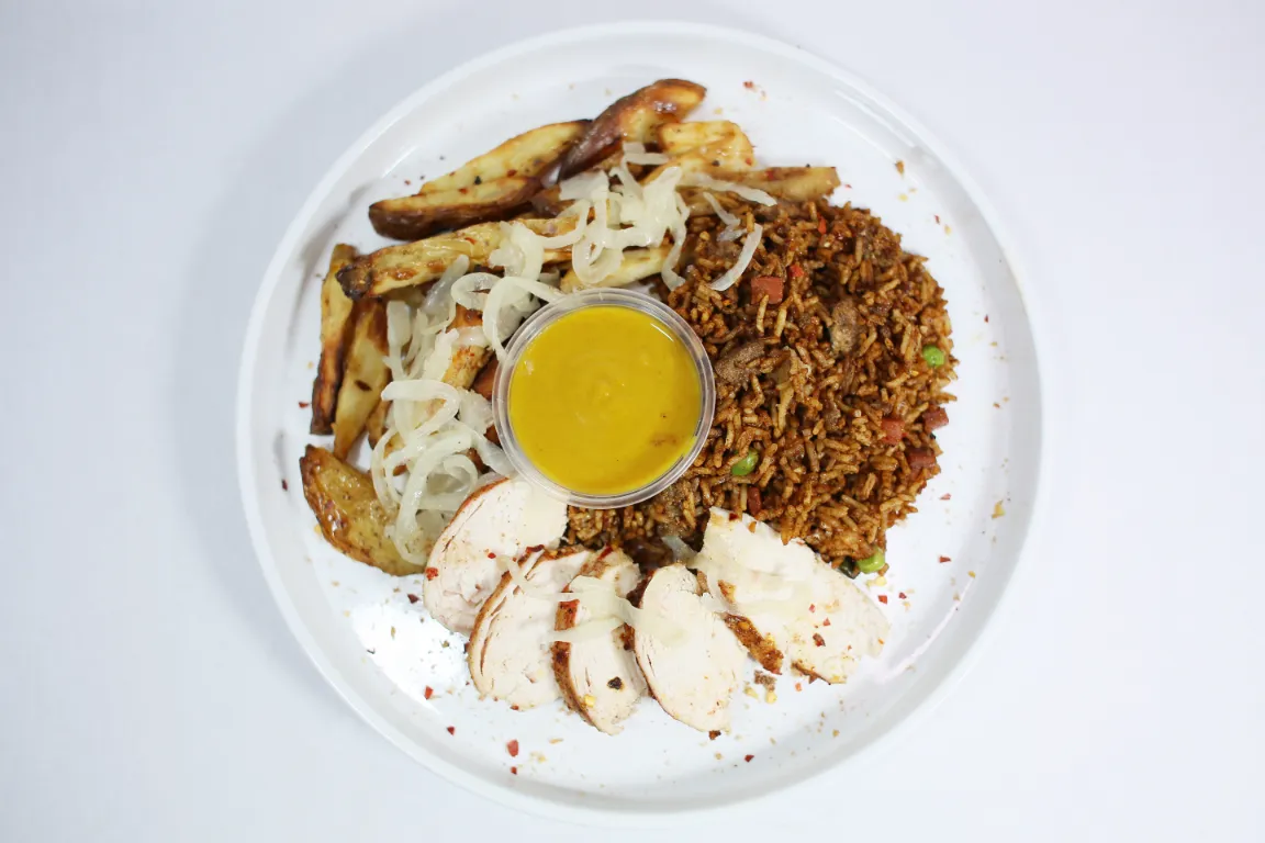 Curry Sauce Salt and Pepper Munchie Box, combo featuring chicken, potato wedges tossed in a savoury blend of salt, pepper, and aromatic spices, alongside a portion of flavourful fried rice, paired with a classic curry sauce.