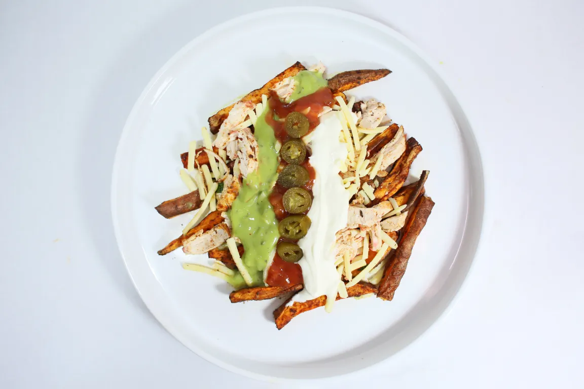 Loaded Fajita Wedges with chicken, sweet potato, fajita-seasoned chicken, melted cheese, salsa, guacamole, crème fraîche, and jalapeños.