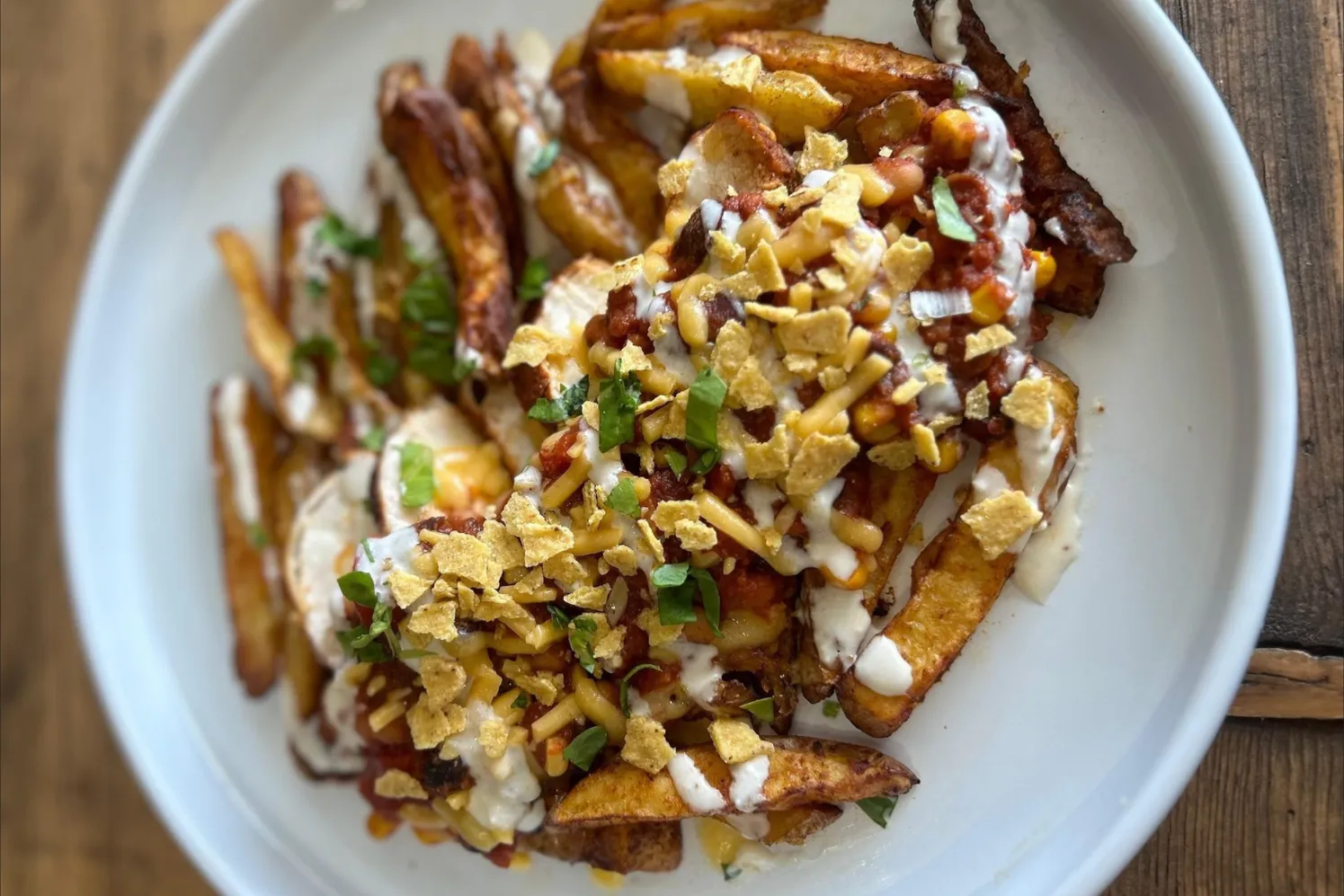 A vibrant dish of Tex-Mex loaded wedges with crispy potato wedges, seasoned chicken (or beef/halloumi), beans, sweetcorn, cheese, and fresh toppings.