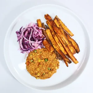 A plant-based burger served with roasted sweet potato wedges and a side of fresh slaw.