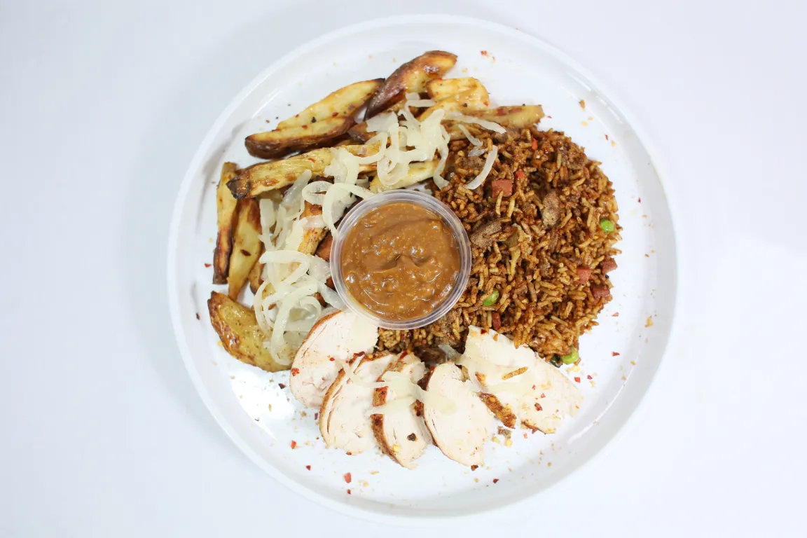 Satay Sauce Salt and Pepper Munchie Box, combo featuring chicken, potato wedges tossed in a savoury blend of salt, pepper, and aromatic spices, alongside a portion of flavourful fried rice, paired with a rich satay sauce.