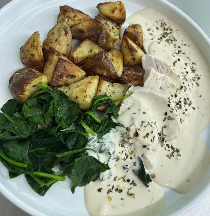 Chicken with a creamy spinach and peppercorn sauce, paired with crispy herby potatoes.