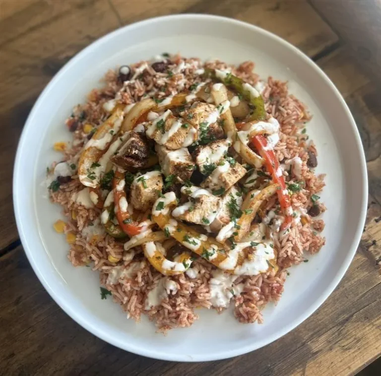 Mexican Fiesta Rice with Chicken featuring grilled chicken breast, spicy rice, black and kidney beans, peppers, onions, and garlic mayo drizzle