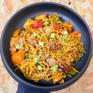Sweet Chilli Noodles with chicken, peppers, onions and sesame seeds in a glossy sweet chilli glaze
