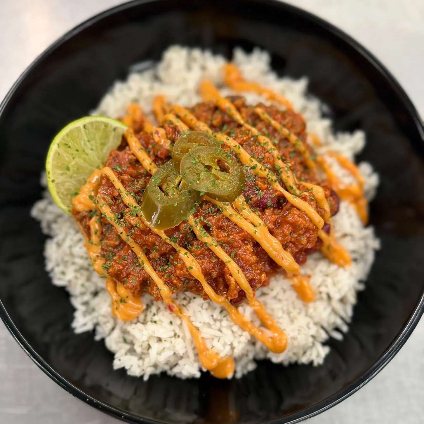 Chilli bowl with beef chilli, rice, chipotle mayo, jalapeños and lime