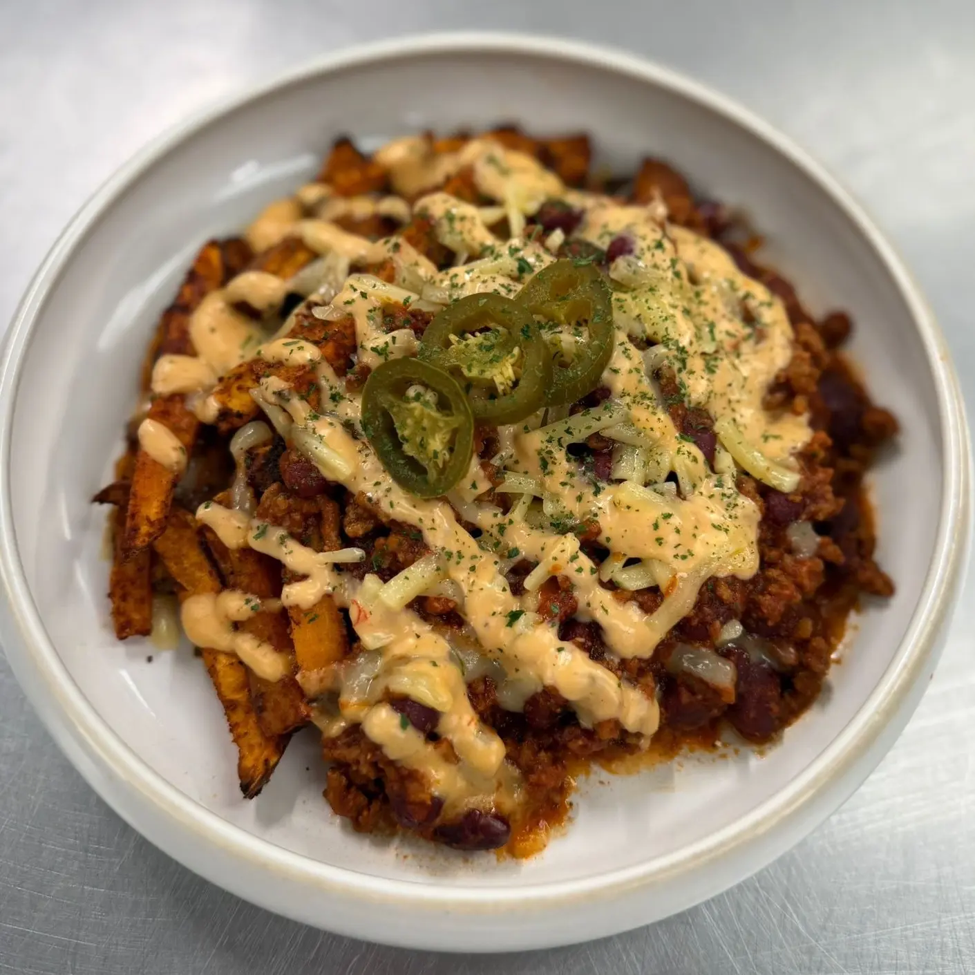 Loaded Sweet Potato Fries with beef chilli, melted cheddar and fresh toppings